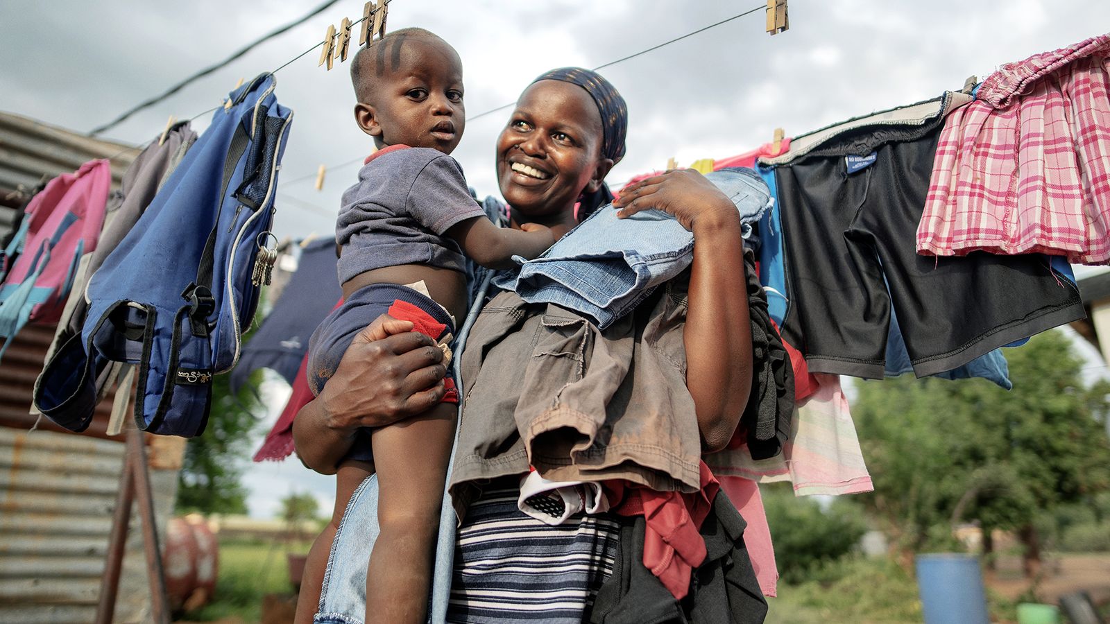 Uma mulher segurando seu bebê nos braços - Fotorreportagem da Nigéria - Poliomielite